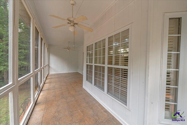 unfurnished sunroom featuring ceiling fan