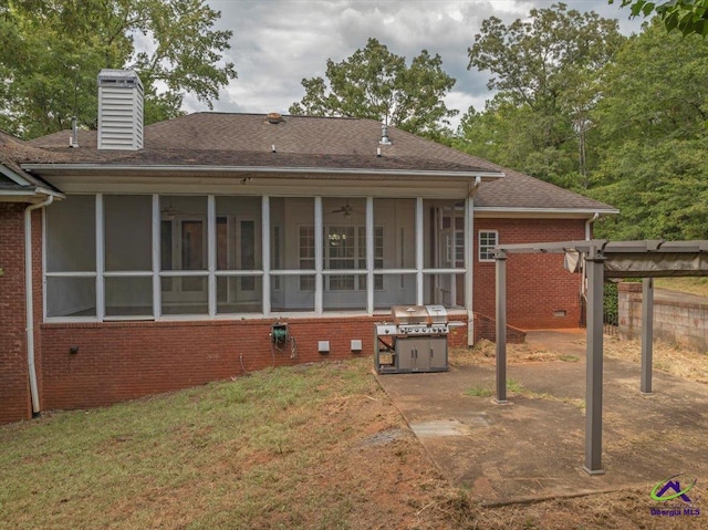 rear view of property with a sunroom, a yard, and a patio area