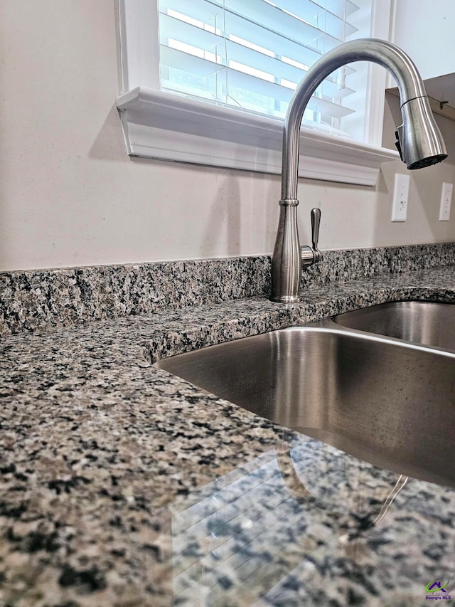 details featuring sink and dark stone counters