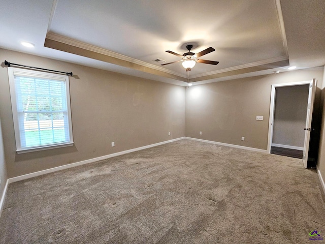 carpeted empty room featuring crown molding, ceiling fan, and a tray ceiling