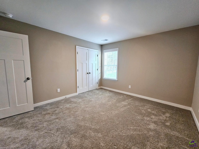 unfurnished bedroom featuring carpet flooring and a closet