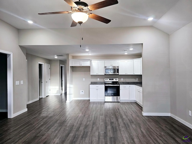kitchen featuring dark wood-type flooring, appliances with stainless steel finishes, vaulted ceiling, and white cabinets