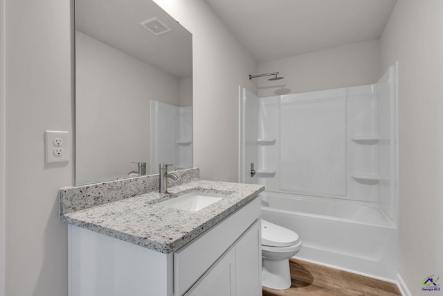 full bathroom featuring vanity, toilet,  shower combination, and hardwood / wood-style floors