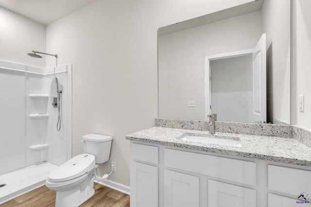 bathroom featuring hardwood / wood-style flooring, vanity, a shower, and toilet