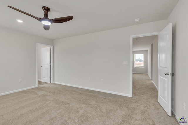 carpeted spare room with ceiling fan