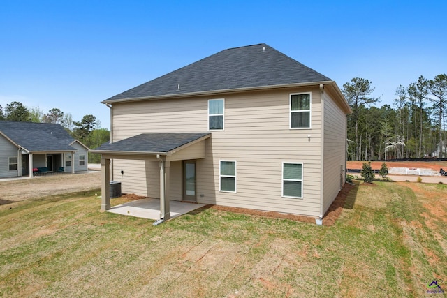 back of house featuring a lawn, central AC unit, and a patio area