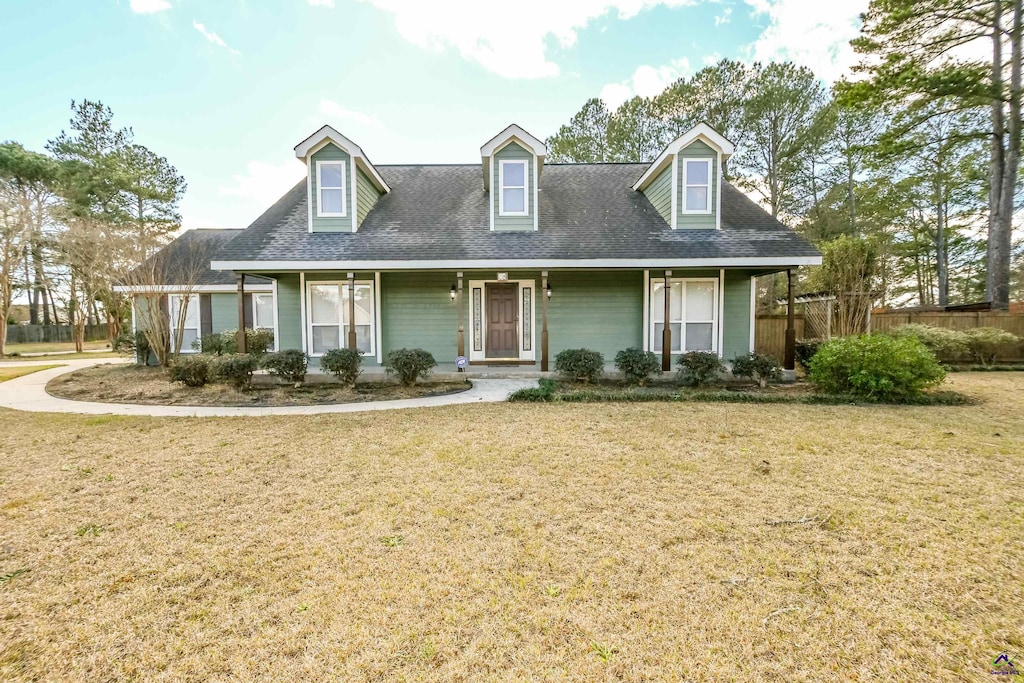 cape cod home with covered porch and a front lawn