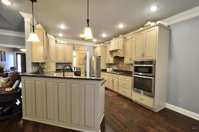 kitchen with appliances with stainless steel finishes, decorative light fixtures, and cream cabinetry