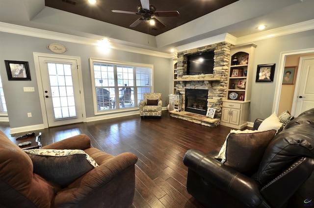 living room featuring ornamental molding, dark hardwood / wood-style flooring, and a tray ceiling