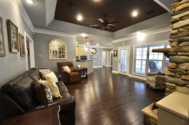 living room with crown molding, dark hardwood / wood-style floors, a raised ceiling, and ceiling fan