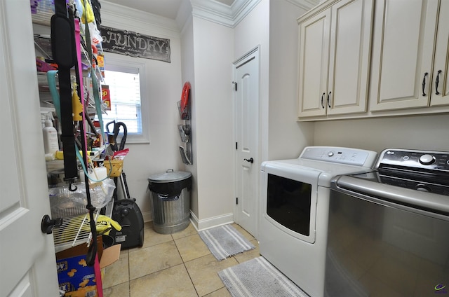 laundry room featuring light tile patterned flooring, cabinets, ornamental molding, and washing machine and dryer