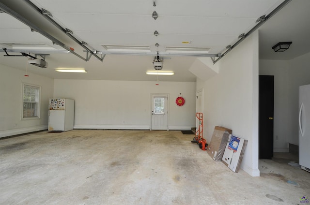 garage featuring a garage door opener and white fridge