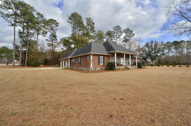 view of side of property featuring a porch and a yard