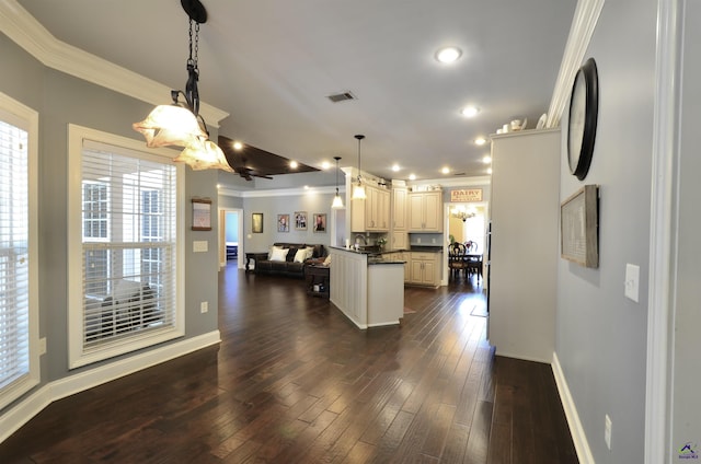 kitchen with dark wood-type flooring, white cabinetry, decorative light fixtures, a center island, and ornamental molding