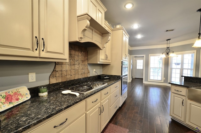 kitchen featuring crown molding, hanging light fixtures, custom range hood, stainless steel appliances, and backsplash