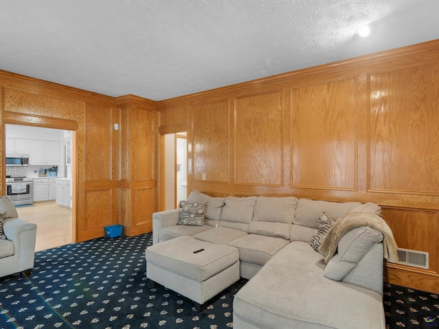 carpeted living room with wood walls