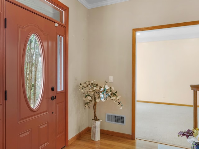 foyer featuring ornamental molding and light hardwood / wood-style floors