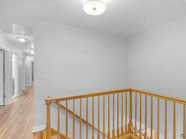 hall featuring a textured ceiling and light wood-type flooring