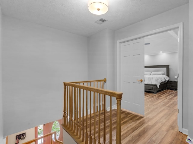 hallway with hardwood / wood-style flooring and a textured ceiling