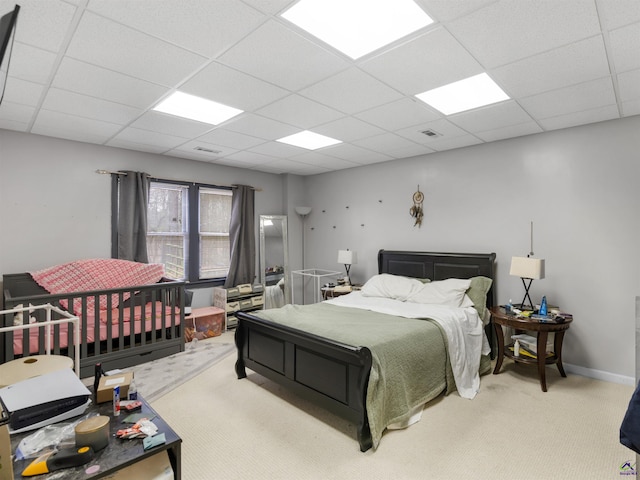 carpeted bedroom with a drop ceiling