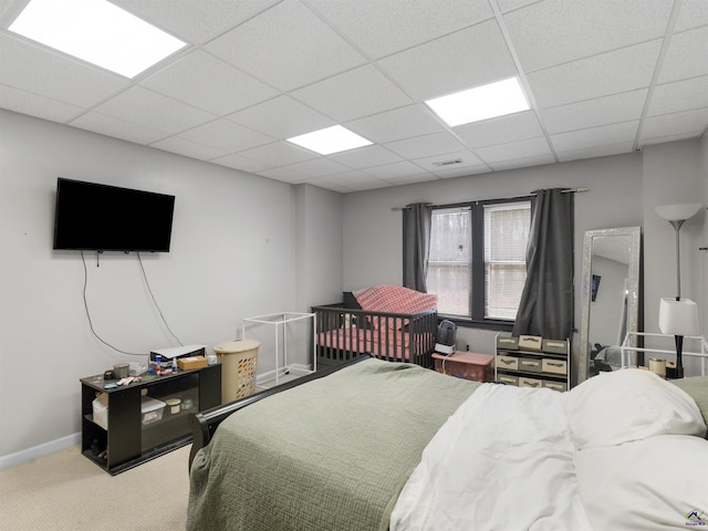 bedroom with carpet floors and a paneled ceiling