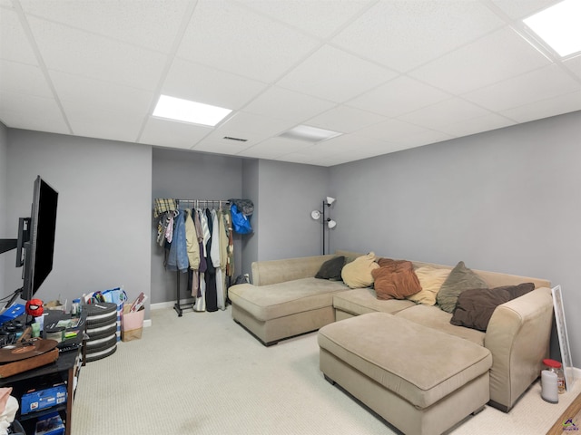 living room featuring a paneled ceiling and carpet