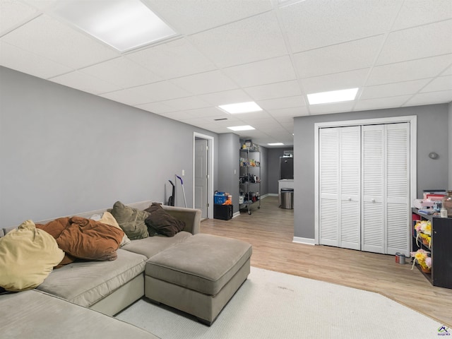 living room featuring hardwood / wood-style flooring and a drop ceiling