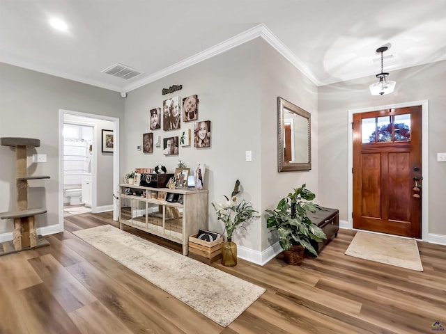 entryway featuring hardwood / wood-style flooring and crown molding