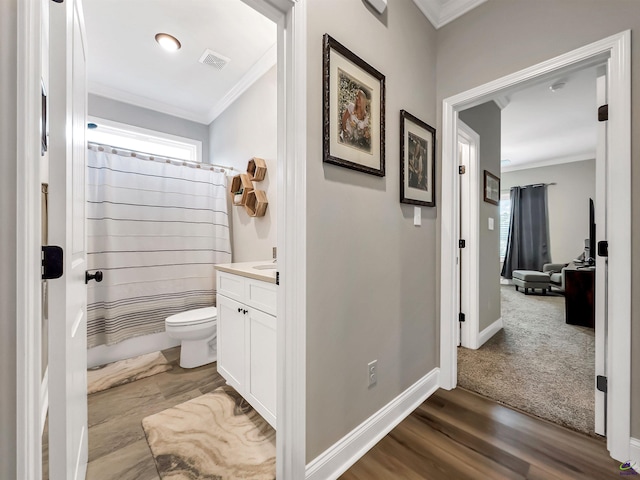 bathroom featuring hardwood / wood-style flooring, ornamental molding, vanity, and toilet