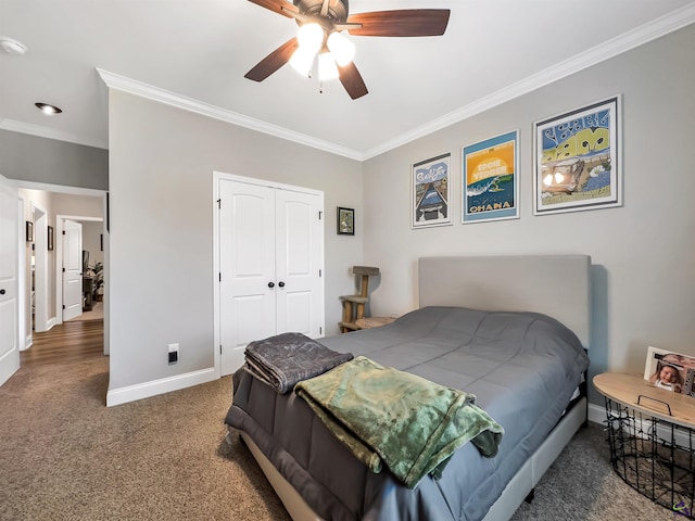 bedroom featuring dark colored carpet, ceiling fan, crown molding, and a closet