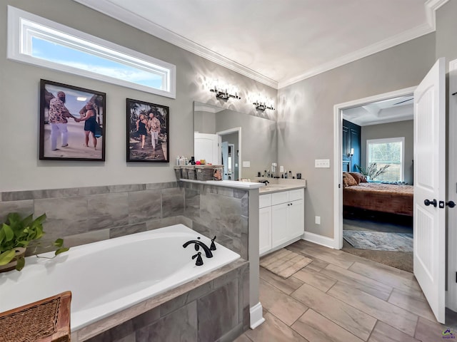 bathroom featuring vanity, tiled tub, and ornamental molding