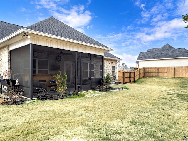 rear view of property featuring a lawn and a sunroom