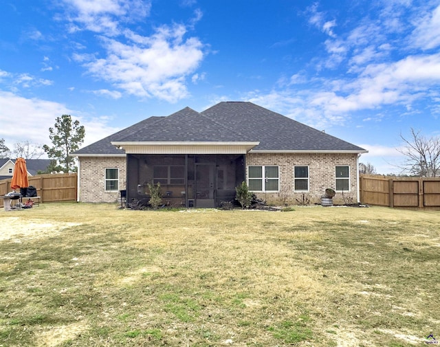 back of house featuring a sunroom and a lawn