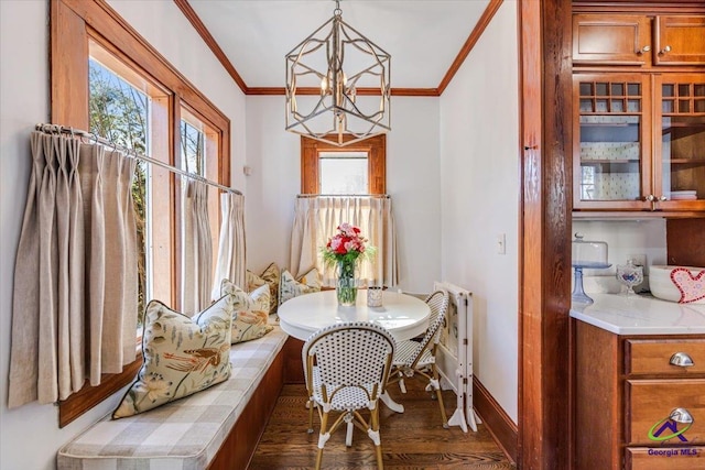 dining area featuring breakfast area, ornamental molding, a chandelier, and dark wood-type flooring