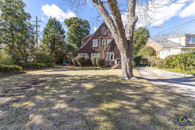 view of side of home featuring a lawn and a playground