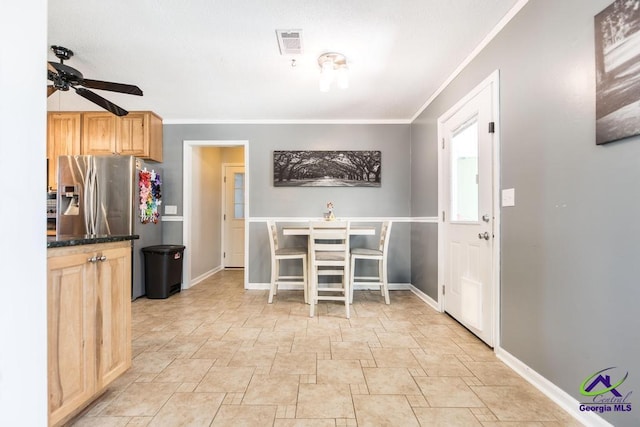 kitchen with crown molding, stainless steel fridge, ceiling fan, and light brown cabinets