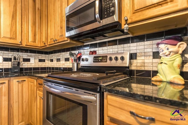 kitchen featuring backsplash, stainless steel appliances, and dark stone countertops