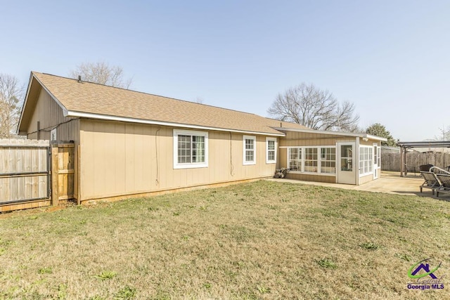 back of property featuring a sunroom, a patio area, and a lawn