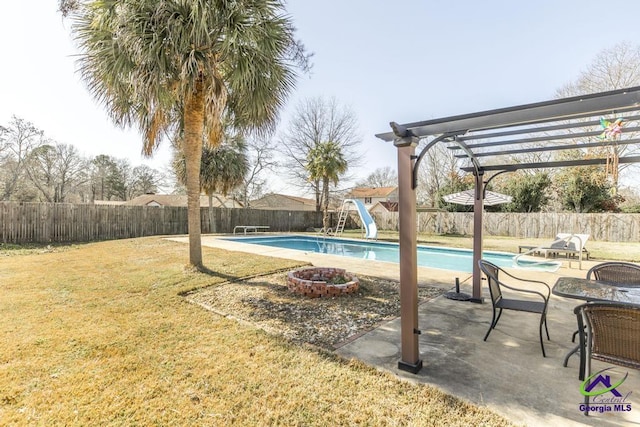 view of swimming pool featuring an outdoor fire pit, a water slide, a pergola, and a yard