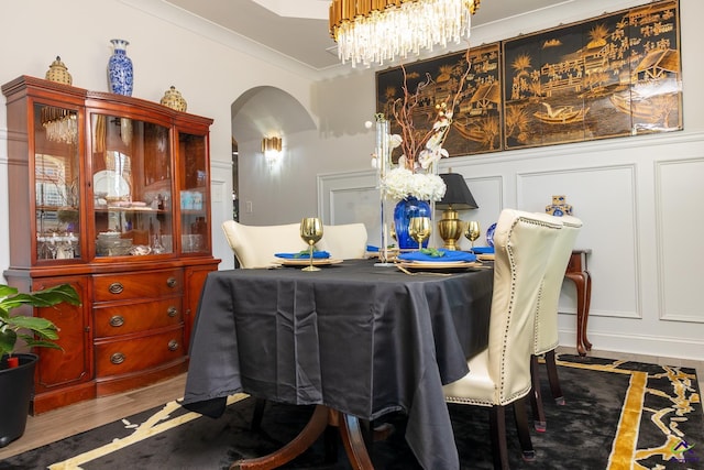 dining area featuring a notable chandelier, dark wood-type flooring, and ornamental molding