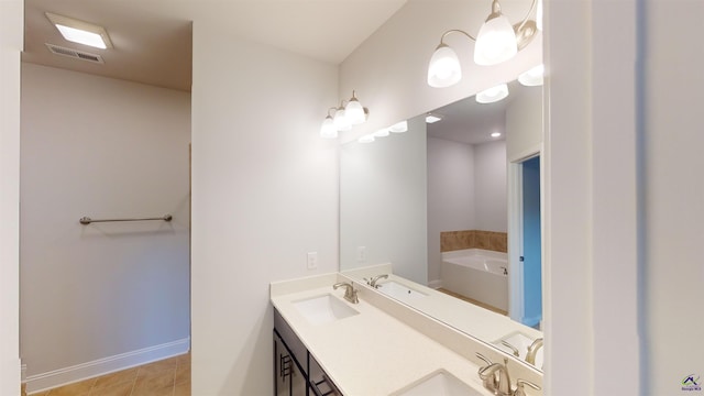 bathroom featuring a tub to relax in, vanity, and tile patterned flooring