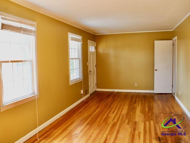 empty room featuring hardwood / wood-style floors and ornamental molding