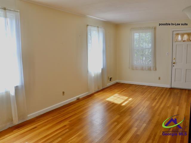 interior space featuring light wood-style flooring, baseboards, a wealth of natural light, and ornamental molding