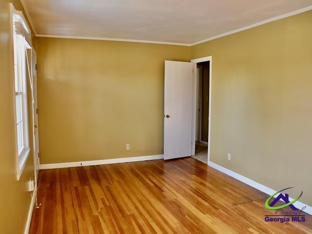 unfurnished room with ornamental molding and hardwood / wood-style flooring