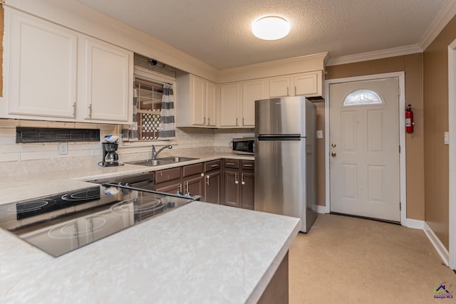 kitchen with ornamental molding, backsplash, stainless steel appliances, light countertops, and a sink