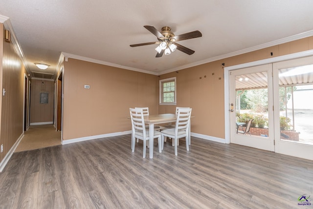 unfurnished dining area featuring a ceiling fan, crown molding, and wood finished floors