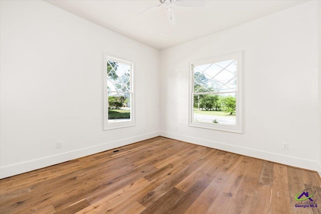 spare room with hardwood / wood-style flooring, ceiling fan, and a wealth of natural light