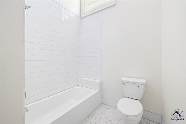 bathroom featuring toilet and tiled shower / bath combo