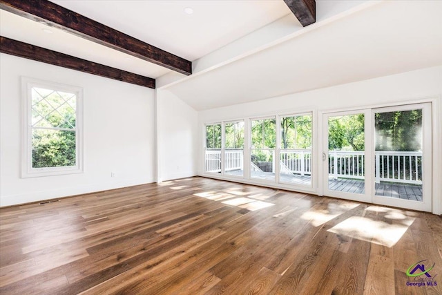 interior space featuring vaulted ceiling with beams, wood-type flooring, and a wealth of natural light