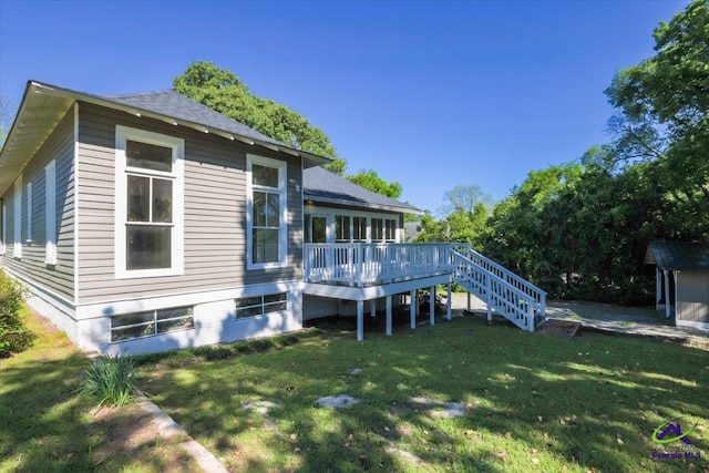 back of property featuring a deck and a lawn